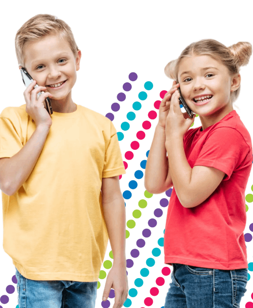 The photo shows two laughing girls holding and looking at a tablet. Behind the children, you can see smiling parents using a laptop.